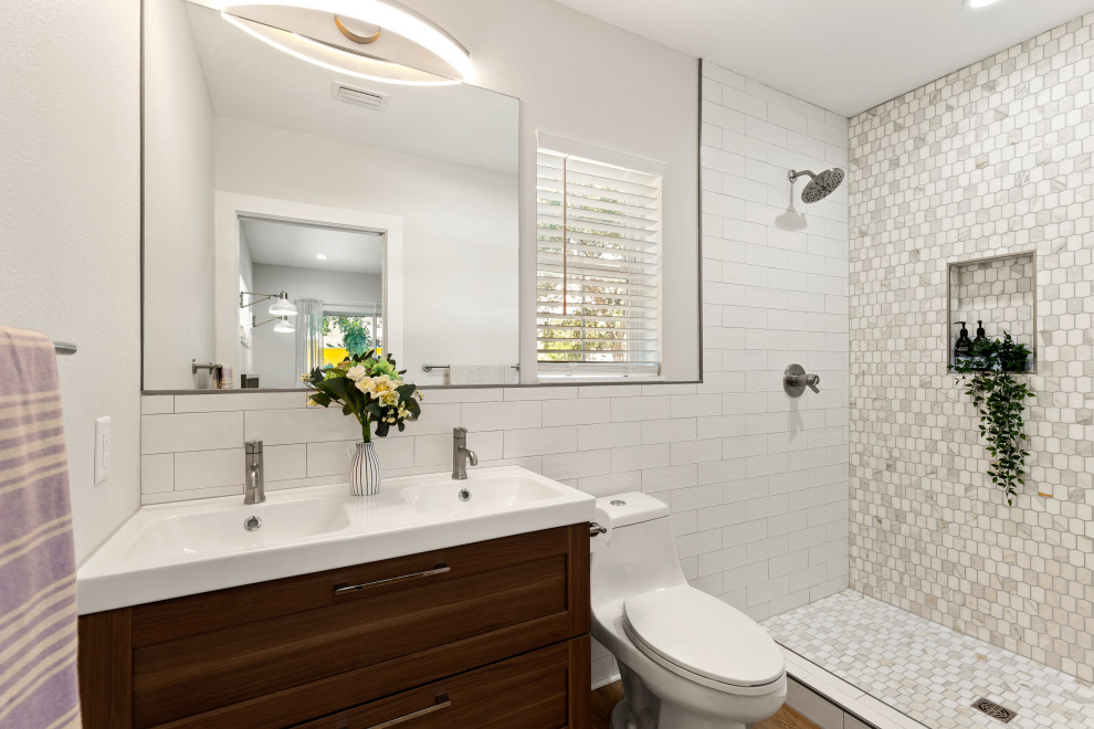 Small contemporary ensuite bathroom in Tampa with a one-piece toilet, white tiles, mosaic tiles, white walls, vinyl flooring, an integrated sink, a shower curtain, double sinks, a wall niche, shaker cabinets, dark wood cabinets, an alcove shower, brown floors and white worktops.