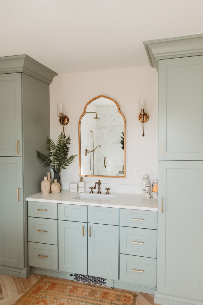 Example of a mid-sized mid-century modern master light wood floor and beige floor alcove shower design in Phoenix with shaker cabinets, green cabinets, white walls, an undermount sink, a hinged shower door and white countertops