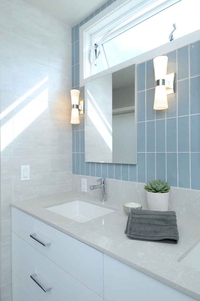 Exempel på ett stort retro badrum, med släta luckor, vita skåp, ett fristående badkar, en öppen dusch, en toalettstol med hel cisternkåpa, porslinskakel, grå väggar, ett undermonterad handfat och laminatbänkskiva