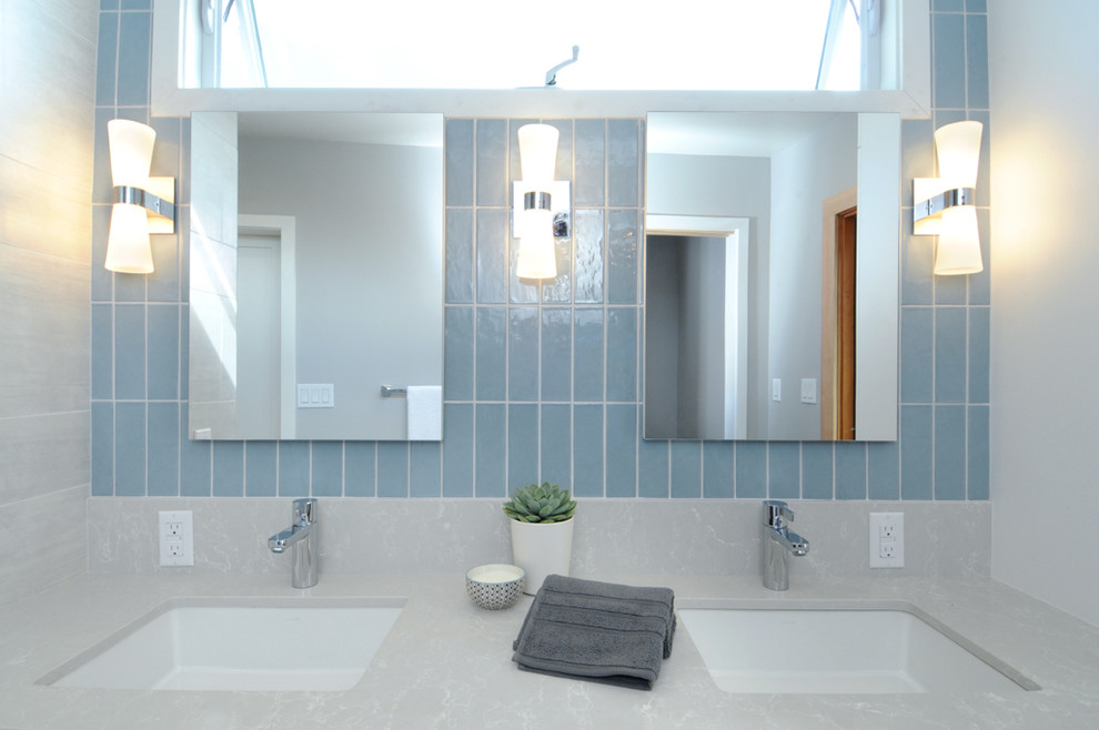 Idée de décoration pour une grande salle de bain vintage avec un placard à porte plane, des portes de placard blanches, une baignoire indépendante, une douche ouverte, WC à poser, des carreaux de porcelaine, un mur gris, un lavabo encastré et un plan de toilette en stratifié.