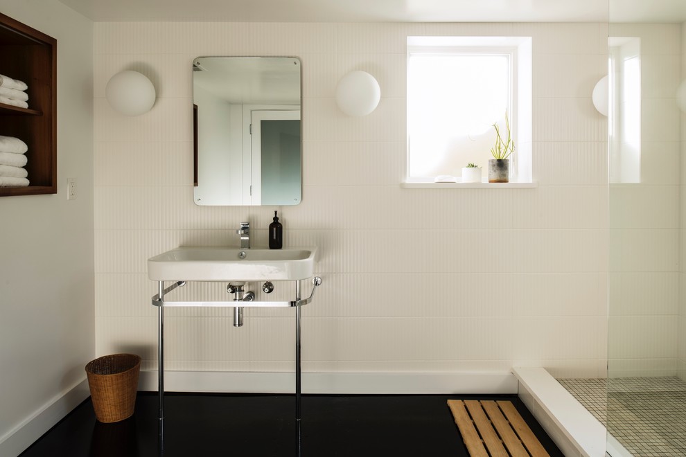 Photo of a large retro ensuite bathroom in Portland with flat-panel cabinets, medium wood cabinets, a walk-in shower, white tiles, white walls, concrete flooring, a console sink, engineered stone worktops, black floors, an open shower and white worktops.