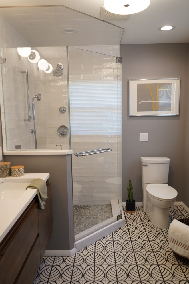 Example of a mid-sized eclectic master black and white tile and subway tile cement tile floor and white floor corner shower design in Philadelphia with furniture-like cabinets, dark wood cabinets, a two-piece toilet, gray walls, an undermount sink, quartz countertops, a hinged shower door and white countertops