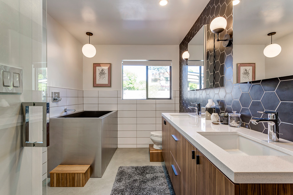 Идея дизайна: главная ванная комната в стиле ретро с плоскими фасадами, темными деревянными фасадами, угловой ванной, душем без бортиков, унитазом-моноблоком, черными стенами, бетонным полом, врезной раковиной, серым полом, открытым душем, белой плиткой и зеркалом с подсветкой