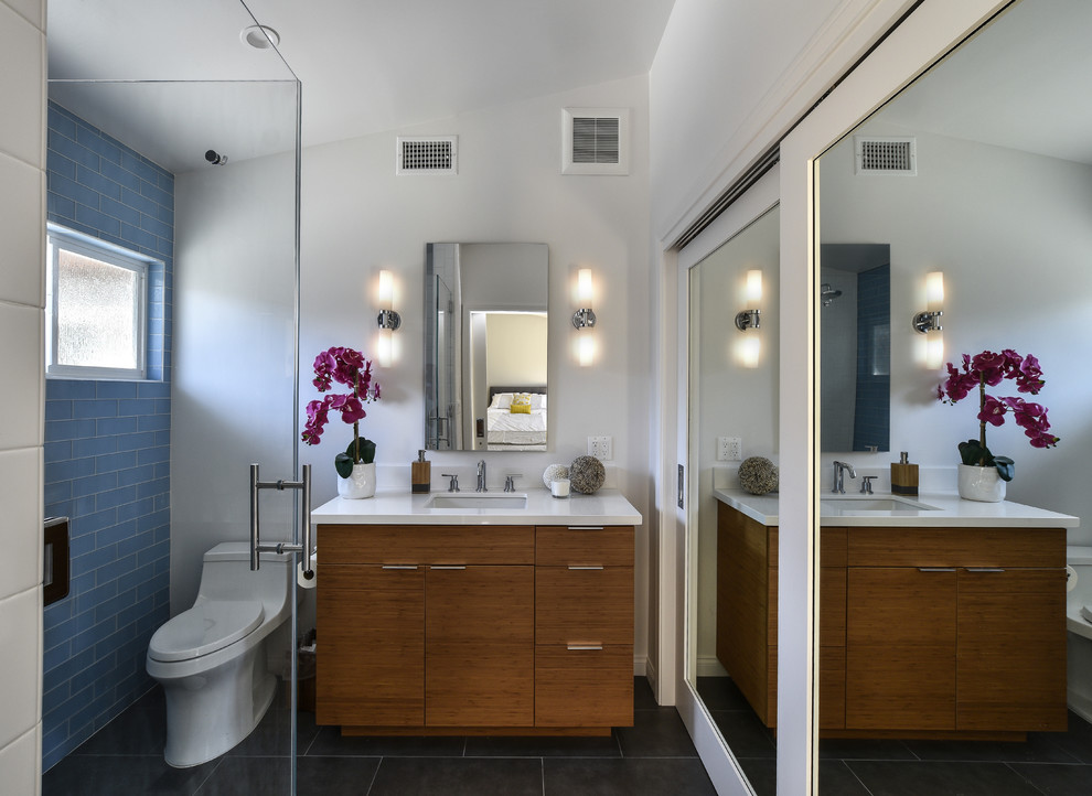 Foto di una stanza da bagno minimalista con piastrelle blu, pareti bianche e porta doccia a battente