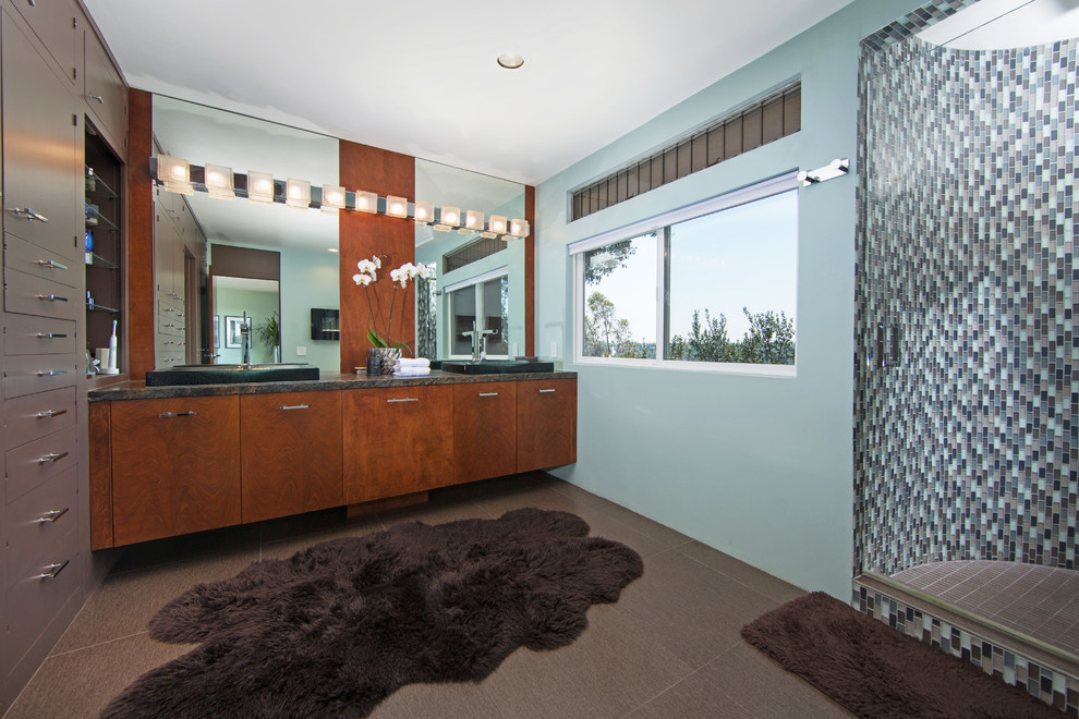 Großes Retro Badezimmer En Suite mit flächenbündigen Schrankfronten, hellbraunen Holzschränken, Duschnische, Toilette mit Aufsatzspülkasten, weißen Fliesen, Porzellanfliesen, blauer Wandfarbe, Porzellan-Bodenfliesen, integriertem Waschbecken und Granit-Waschbecken/Waschtisch in San Diego