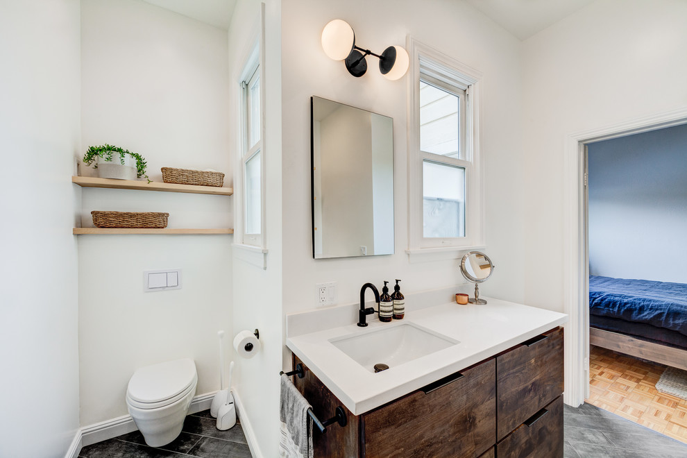 Klassisches Duschbad mit flächenbündigen Schrankfronten, dunklen Holzschränken, Toilette mit Aufsatzspülkasten, weißer Wandfarbe, Unterbauwaschbecken, grauem Boden und brauner Waschtischplatte in San Francisco