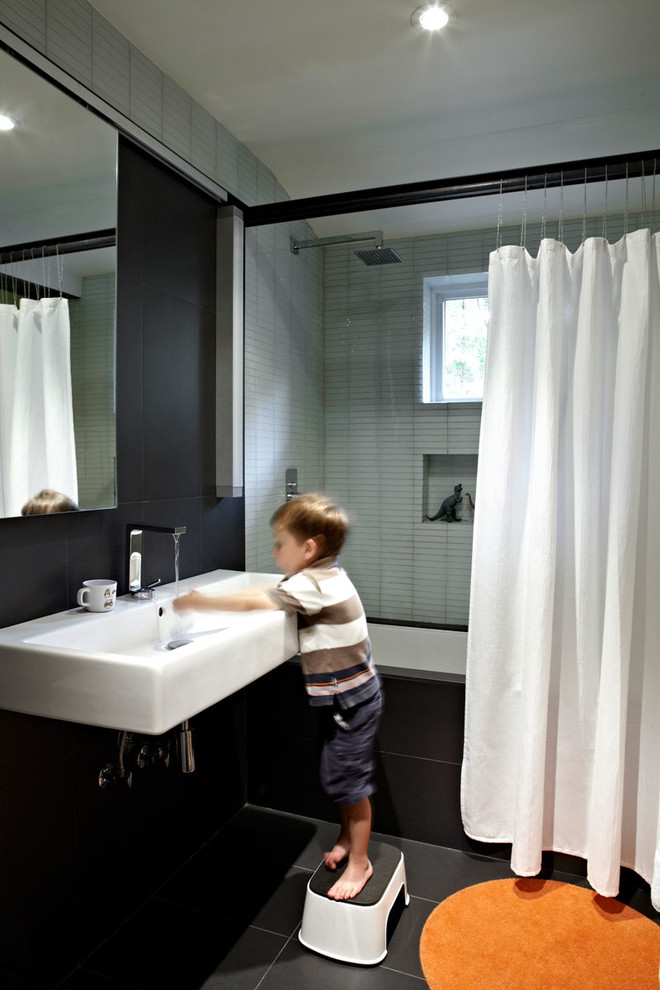 Midcentury bathroom in DC Metro with a wall-mounted sink and black walls.