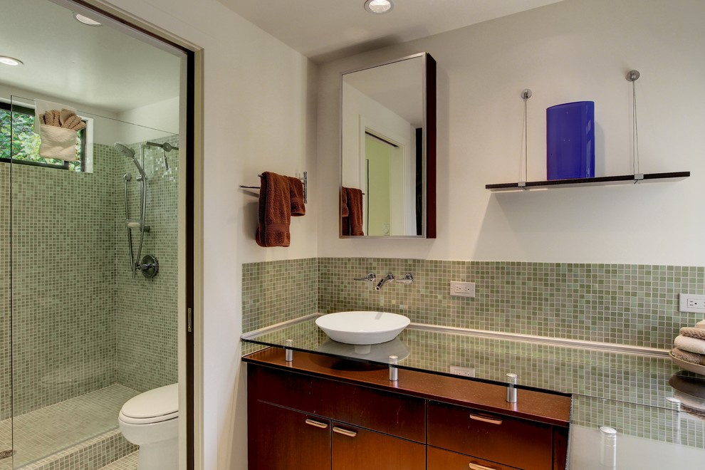 Idéer för ett retro badrum, med ett fristående handfat, släta luckor, skåp i mörkt trä, bänkskiva i glas, grön kakel, glaskakel och vita väggar