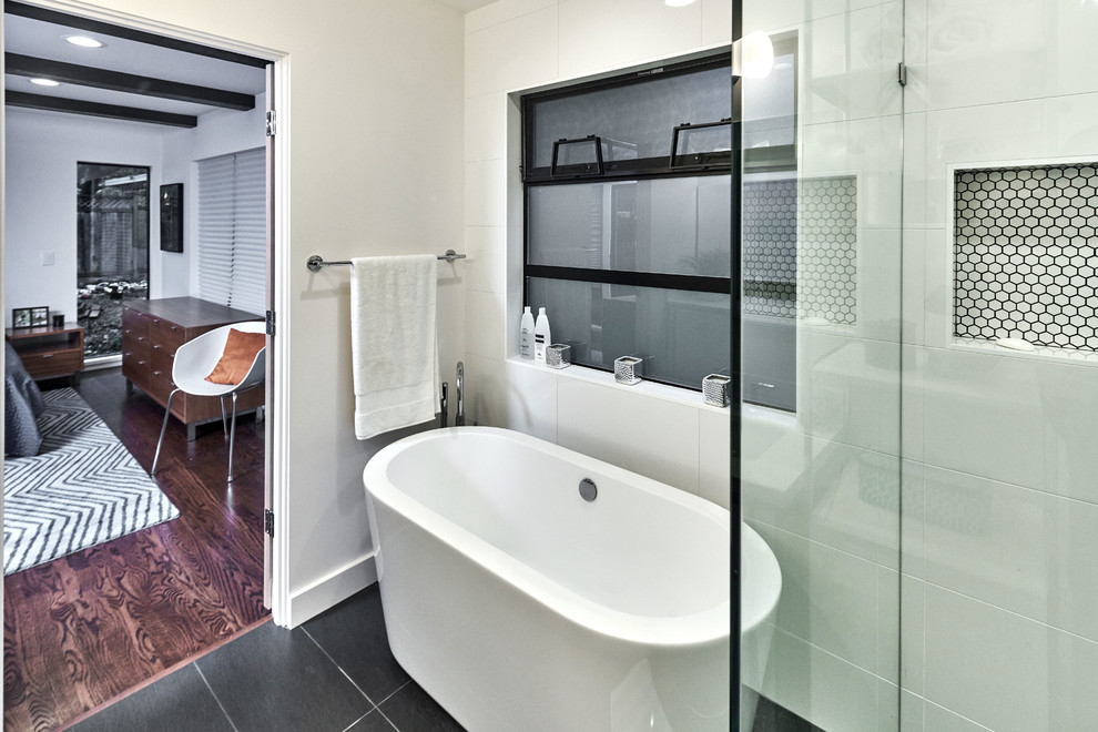 Large 1950s master porcelain tile and black floor freestanding bathtub photo in San Francisco with white walls