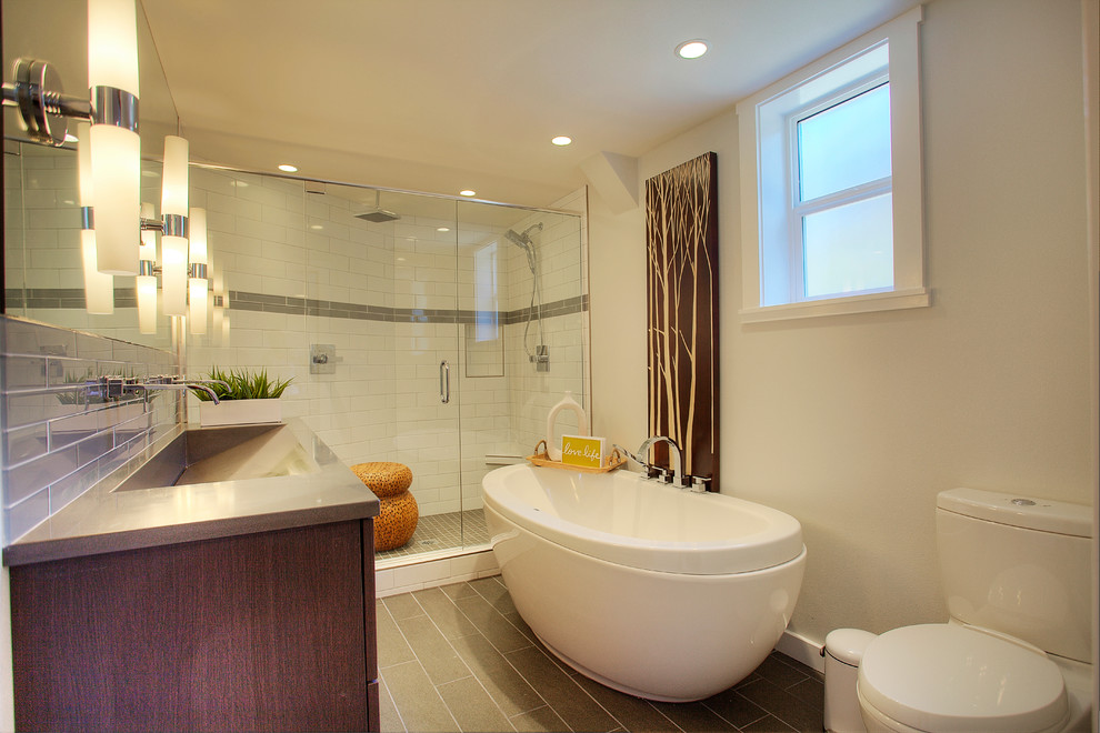 Exempel på ett modernt en-suite badrum, med släta luckor, skåp i mellenmörkt trä, bänkskiva i kvarts, vit kakel, glaskakel, ett fristående badkar, en öppen dusch, en toalettstol med separat cisternkåpa, ett integrerad handfat, vita väggar och klinkergolv i porslin