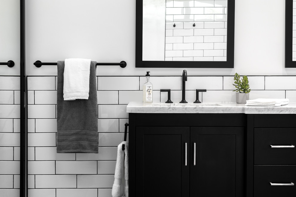 Inredning av ett retro mellanstort en-suite badrum, med släta luckor, svarta skåp, en öppen dusch, en toalettstol med separat cisternkåpa, vit kakel, keramikplattor, vita väggar, klinkergolv i porslin, ett undermonterad handfat, bänkskiva i kvarts, svart golv och med dusch som är öppen