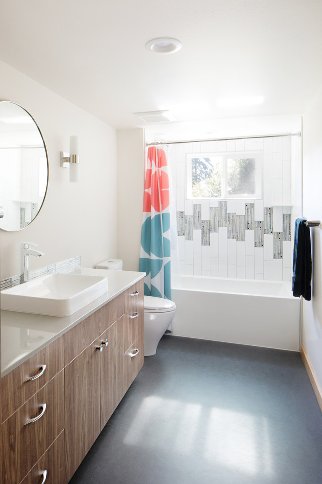 Foto på ett 60 tals vit badrum, med släta luckor, bruna skåp, ett badkar i en alkov, en dusch/badkar-kombination, svart och vit kakel, vita väggar, ett fristående handfat, grått golv och dusch med duschdraperi