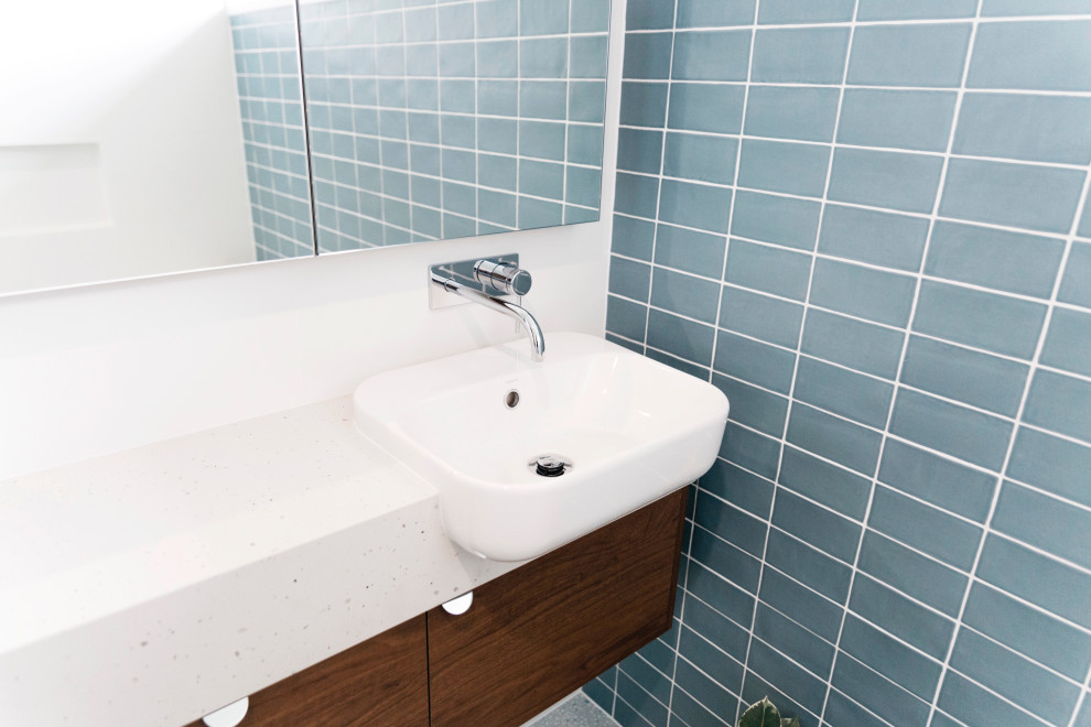 Design ideas for a small retro bathroom in Brisbane with flat-panel cabinets, medium wood cabinets, a freestanding bath, a corner shower, blue tiles, porcelain tiles, white walls, terrazzo flooring, a built-in sink, engineered stone worktops, grey floors, a hinged door, white worktops, a single sink and a floating vanity unit.