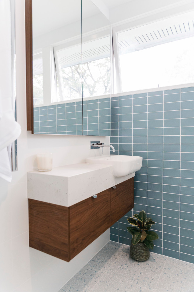 Стильный дизайн: маленькая ванная комната в стиле ретро с плоскими фасадами, фасадами цвета дерева среднего тона, отдельно стоящей ванной, угловым душем, синей плиткой, керамогранитной плиткой, белыми стенами, полом из терраццо, накладной раковиной, столешницей из искусственного кварца, серым полом, душем с распашными дверями, белой столешницей, тумбой под одну раковину и подвесной тумбой для на участке и в саду - последний тренд