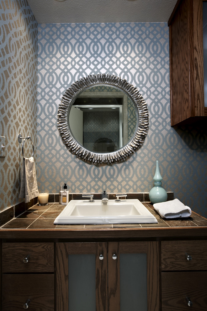 Foto di una stanza da bagno con doccia moderna con top piastrellato, pareti multicolore, lavabo da incasso, ante di vetro, piastrelle grigie e ante in legno bruno