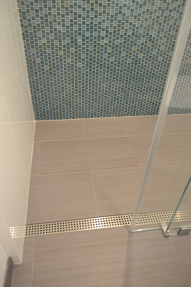Foto på ett mellanstort 60 tals vit badrum med dusch, med släta luckor, skåp i mellenmörkt trä, en kantlös dusch, bänkskiva i kvarts, dusch med gångjärnsdörr, blå kakel och glaskakel