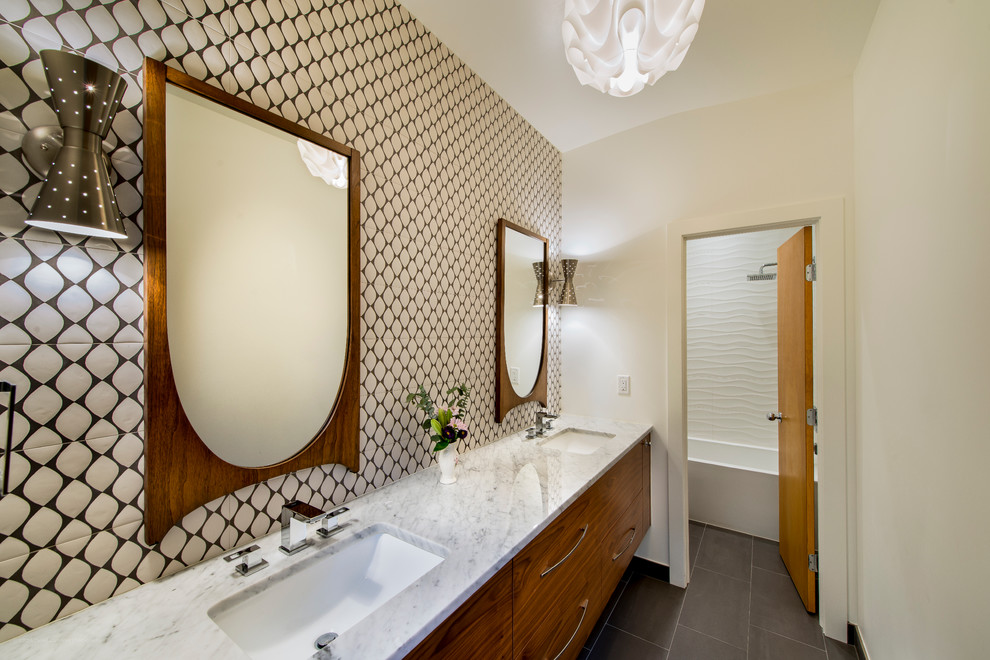 Cette photo montre une salle de bain principale rétro en bois brun de taille moyenne avec un placard à porte plane, un carrelage marron, un carrelage blanc, des carreaux de céramique, un mur beige, un sol en carrelage de céramique, un lavabo encastré et un plan de toilette en marbre.