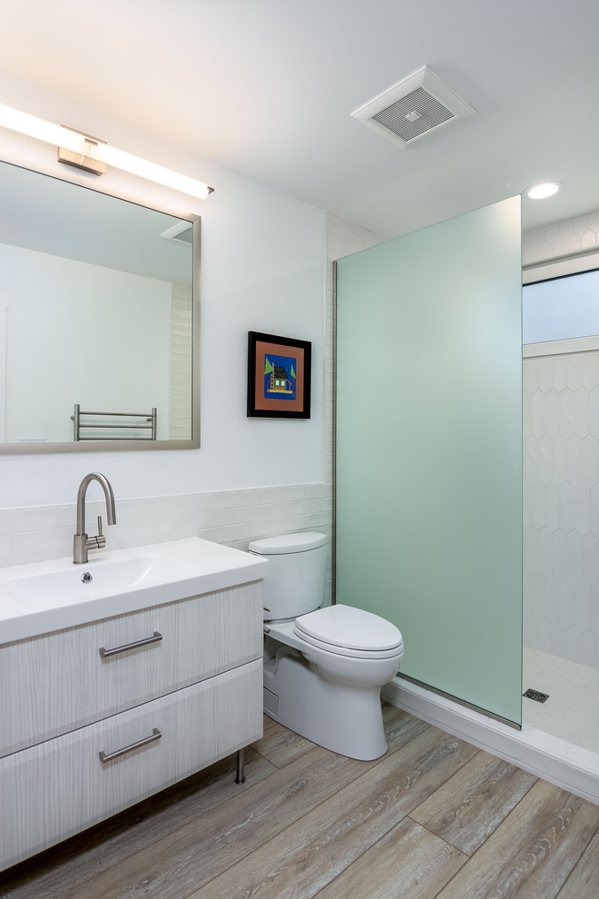 Huge 1960s kids' white tile and porcelain tile ceramic tile, white floor and single-sink bathroom photo in Portland with flat-panel cabinets, white cabinets, a two-piece toilet, white walls, an integrated sink, quartz countertops, white countertops and a freestanding vanity