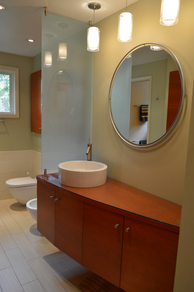Inspiration for a large mid-century modern master white tile and porcelain tile porcelain tile alcove shower remodel in Cincinnati with a vessel sink, flat-panel cabinets, medium tone wood cabinets, glass countertops, a two-piece toilet and beige walls