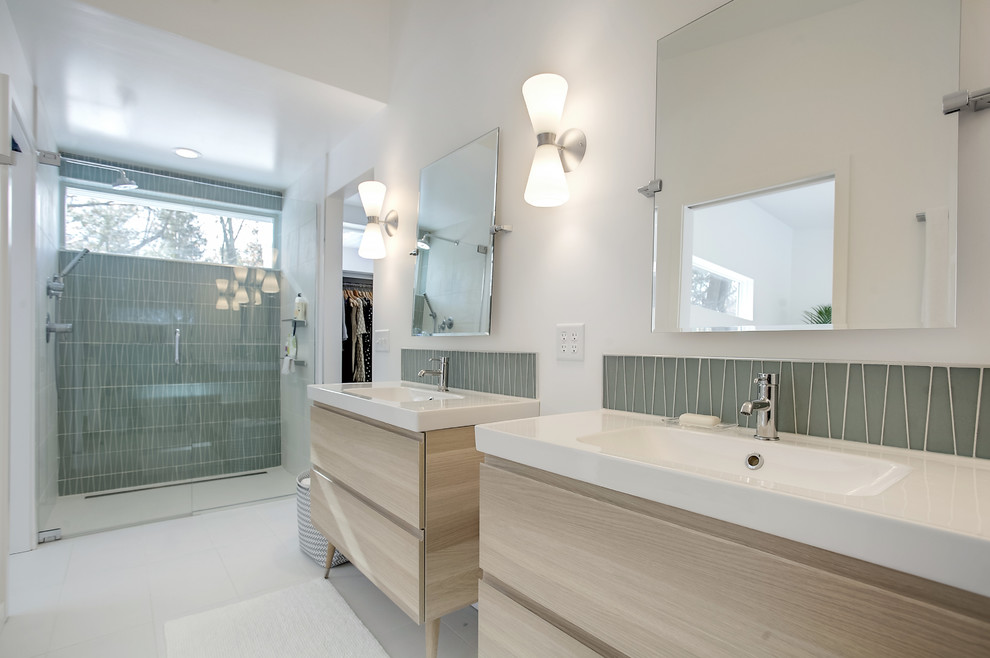 Mittelgroßes Mid-Century Badezimmer En Suite mit flächenbündigen Schrankfronten, hellen Holzschränken, bodengleicher Dusche, grünen Fliesen, Glasfliesen, Keramikboden, integriertem Waschbecken, weißem Boden, Falttür-Duschabtrennung, weißer Wandfarbe und Quarzit-Waschtisch in Grand Rapids