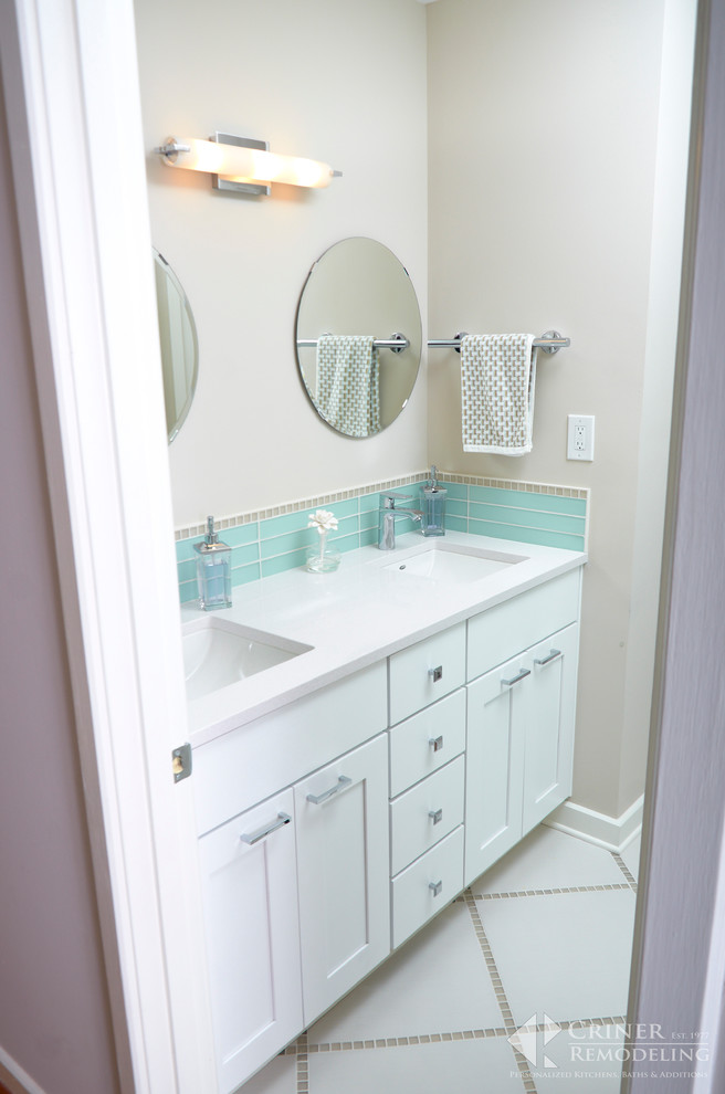 Imagen de cuarto de baño retro con puertas de armario blancas y suelo de baldosas de porcelana