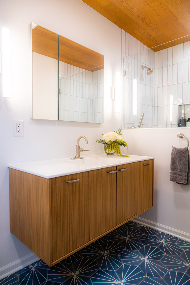 Exempel på ett 50 tals vit vitt en-suite badrum, med släta luckor, skåp i ljust trä, en kantlös dusch, vit kakel, keramikplattor, vita väggar, cementgolv, ett integrerad handfat, blått golv och dusch med gångjärnsdörr