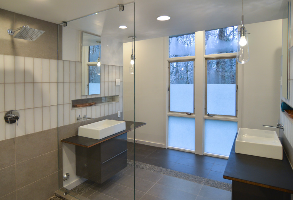 Example of a large minimalist master gray tile and ceramic tile ceramic tile and gray floor bathroom design in Raleigh with flat-panel cabinets, gray cabinets, a wall-mount toilet, white walls, a vessel sink and wood countertops
