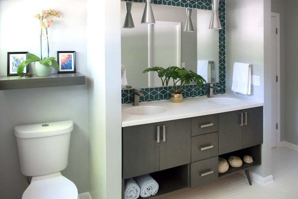 Bild på ett mellanstort 60 tals vit vitt en-suite badrum, med släta luckor, skåp i mörkt trä, en toalettstol med separat cisternkåpa, grå väggar, ett undermonterad handfat, bänkskiva i akrylsten, vitt golv, en dusch i en alkov, grön kakel, keramikplattor, mosaikgolv och dusch med skjutdörr