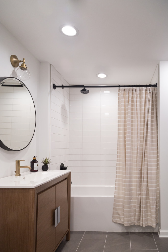 На фото: ванная комната в современном стиле с плоскими фасадами, фасадами цвета дерева среднего тона, ванной в нише, душем над ванной, белой плиткой, белыми стенами, консольной раковиной, серым полом и шторкой для ванной