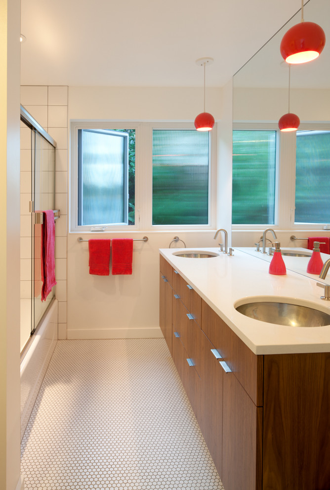 Пример оригинального дизайна: ванная комната в стиле ретро с врезной раковиной, плоскими фасадами, фасадами цвета дерева среднего тона, ванной в нише, душем над ванной, белыми стенами и полом из мозаичной плитки
