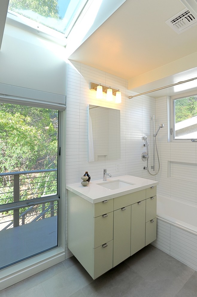 Cette photo montre une salle de bain tendance avec un lavabo encastré, un placard à porte plane, des portes de placards vertess, une baignoire en alcôve, un combiné douche/baignoire, un carrelage blanc et une fenêtre.