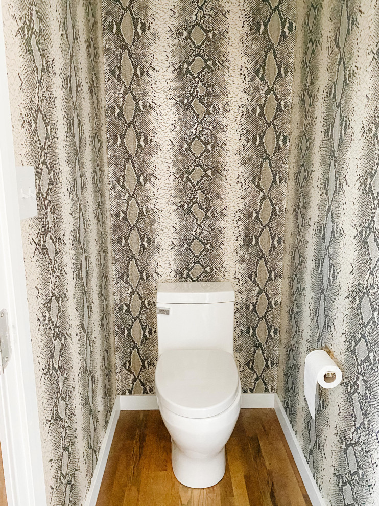 Cette image montre un WC et toilettes vintage de taille moyenne avec WC à poser, un carrelage multicolore, un mur blanc, un sol en bois brun, un sol marron, meuble-lavabo suspendu et du papier peint.