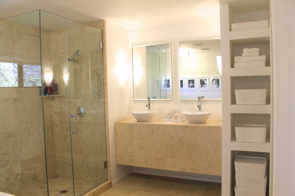 На фото: главная ванная комната среднего размера в стиле ретро с настольной раковиной, открытыми фасадами, столешницей из известняка, угловым душем, бежевой плиткой, каменной плиткой, белыми стенами и полом из травертина с