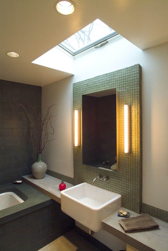 Réalisation d'une salle de bain minimaliste avec un lavabo suspendu, un plan de toilette en stéatite, une baignoire encastrée, un carrelage vert, un carrelage en pâte de verre, un mur vert et un sol en linoléum.