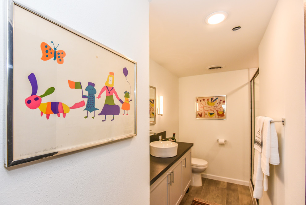 Foto på ett mellanstort retro badrum, med luckor med infälld panel, vita skåp, en kantlös dusch, vita väggar, klinkergolv i porslin, ett fristående handfat, bänkskiva i kvartsit, beiget golv och dusch med skjutdörr