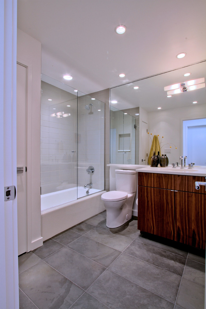 Свежая идея для дизайна: детская ванная комната среднего размера в стиле ретро с плоскими фасадами, темными деревянными фасадами, ванной в нише, душем над ванной, раздельным унитазом, серой плиткой, керамогранитной плиткой, белыми стенами, полом из сланца, врезной раковиной, столешницей из искусственного кварца, серым полом и душем с распашными дверями - отличное фото интерьера