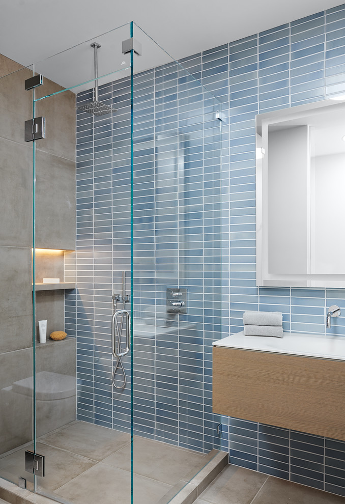 Mid-Century Badezimmer mit flächenbündigen Schrankfronten, hellbraunen Holzschränken, Eckdusche, blauen Fliesen, integriertem Waschbecken, grauem Boden, Falttür-Duschabtrennung und weißer Waschtischplatte in San Francisco