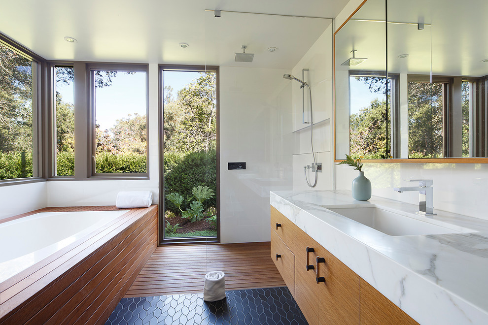 Mid-sized mid-century modern master medium tone wood floor and black floor bathroom photo in San Francisco with an undermount sink, flat-panel cabinets, an undermount tub, white walls, light wood cabinets and marble countertops