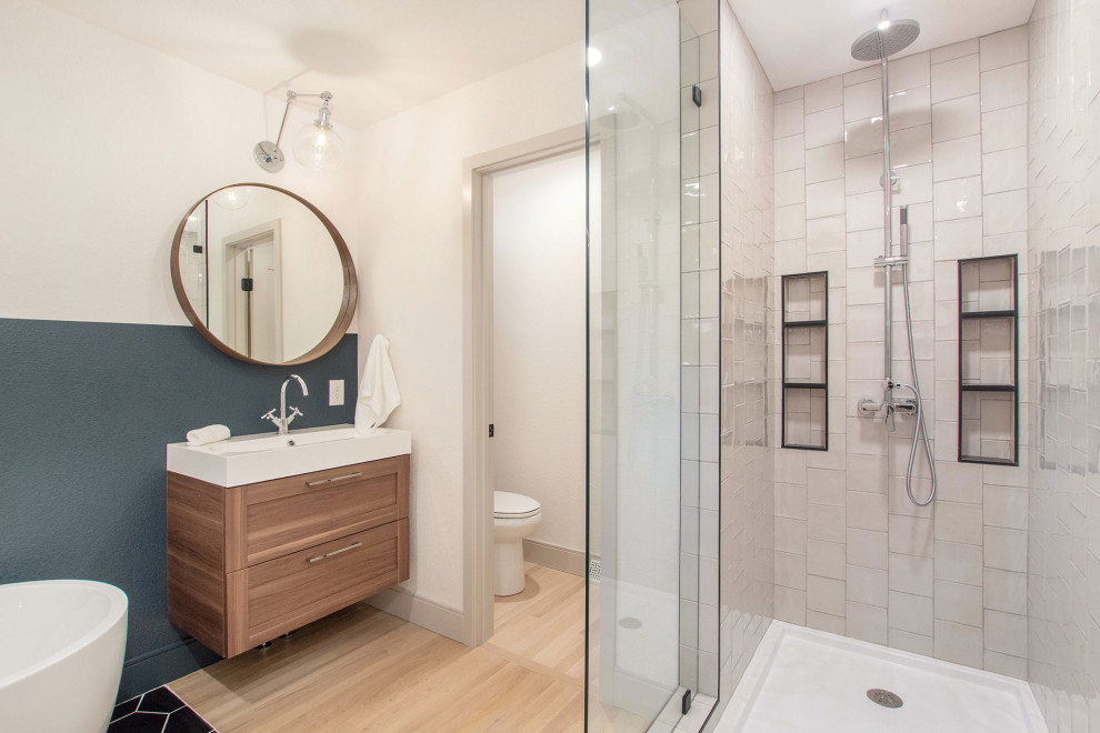 Inspiration for a mid-sized 1950s master beige tile and porcelain tile light wood floor and beige floor bathroom remodel in Denver with shaker cabinets, medium tone wood cabinets, a two-piece toilet, white walls, an integrated sink, quartz countertops and white countertops