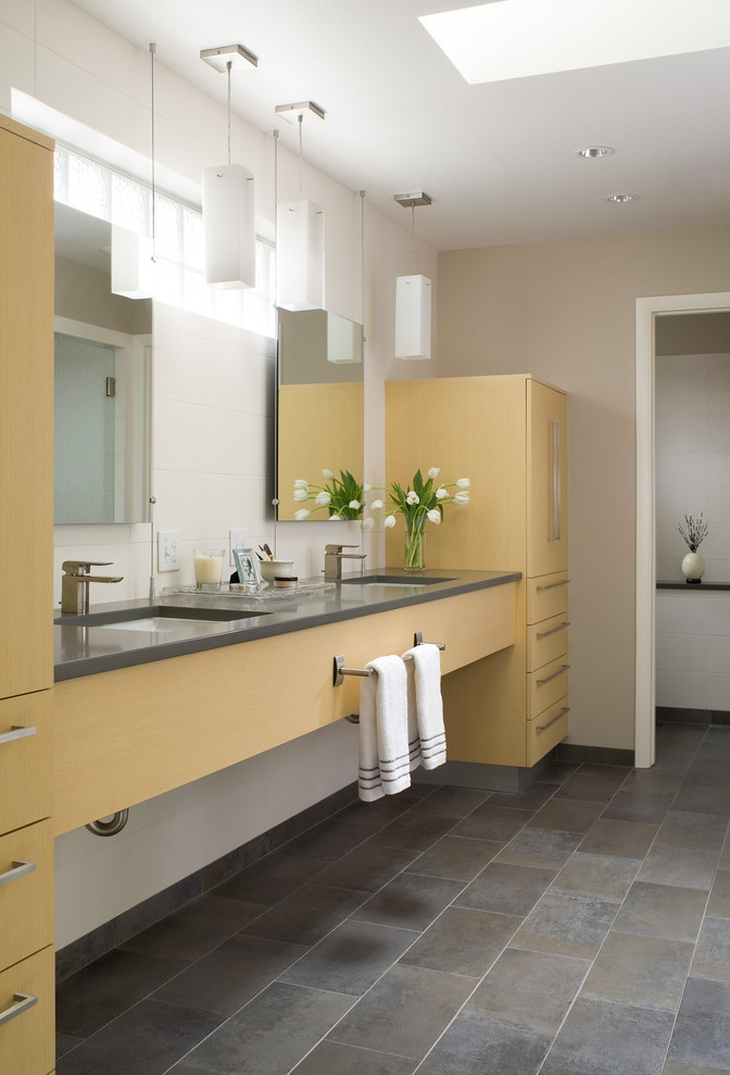 Exemple d'une douche en alcôve principale tendance en bois clair avec un lavabo encastré, un plan de toilette gris, un placard à porte plane, un sol en carrelage de porcelaine, un plan de toilette en quartz modifié, un sol gris et une cabine de douche à porte battante.