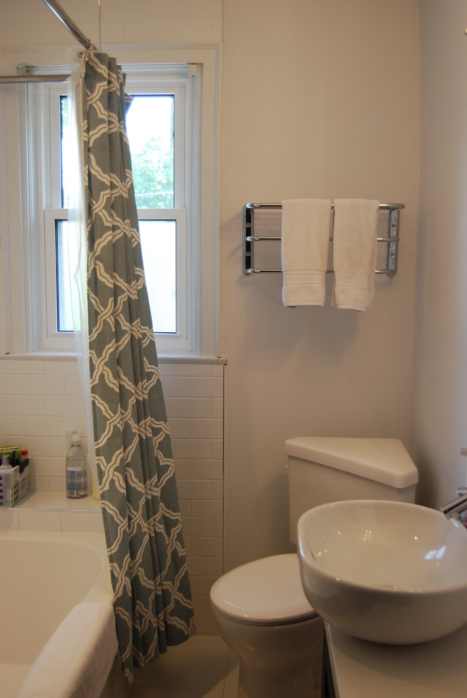 Foto på ett litet maritimt badrum, med ett fristående handfat, skåp i shakerstil, skåp i mörkt trä, bänkskiva i kvarts, ett badkar i en alkov, en dusch/badkar-kombination, en toalettstol med separat cisternkåpa, vit kakel, porslinskakel, blå väggar och klinkergolv i keramik