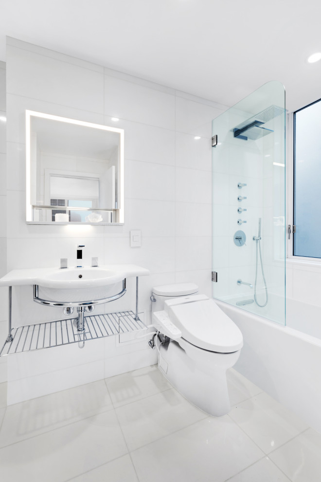 Стильный дизайн: ванная комната в современном стиле с ванной в нише, душем над ванной, белой плиткой, подвесной раковиной, серым полом, открытым душем, тумбой под одну раковину и зеркалом с подсветкой - последний тренд