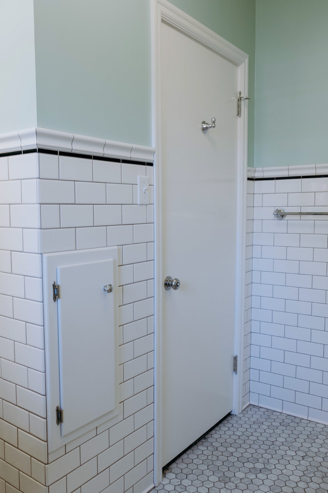 Inredning av ett 50 tals litet badrum med dusch, med skåp i shakerstil, vita skåp, en dusch i en alkov, en toalettstol med hel cisternkåpa, vit kakel, tunnelbanekakel, gröna väggar, klinkergolv i keramik, ett piedestal handfat, grått golv och dusch med gångjärnsdörr