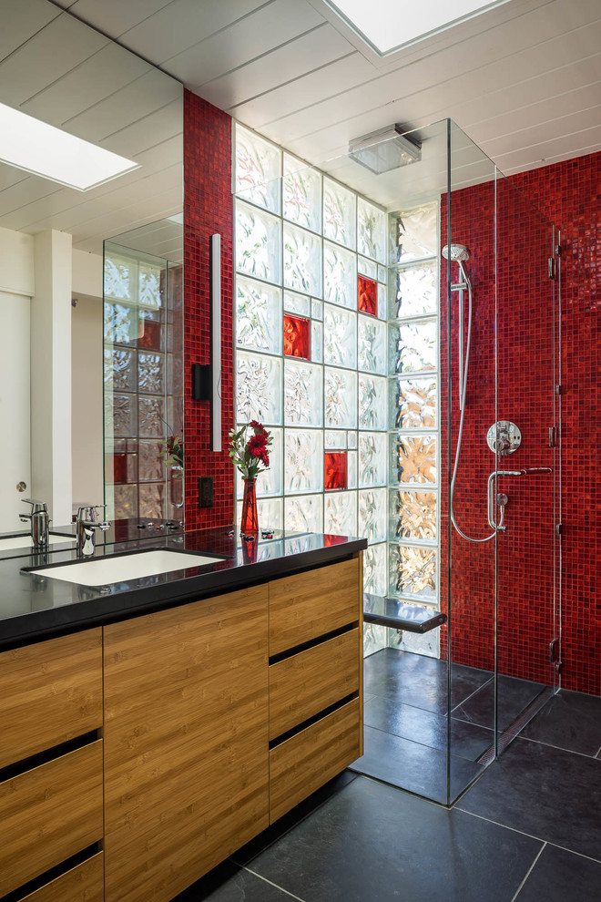 Стильный дизайн: ванная комната в стиле ретро с плоскими фасадами, фасадами цвета дерева среднего тона, душем без бортиков, красной плиткой, плиткой мозаикой, белыми стенами, врезной раковиной, черным полом и черной столешницей - последний тренд