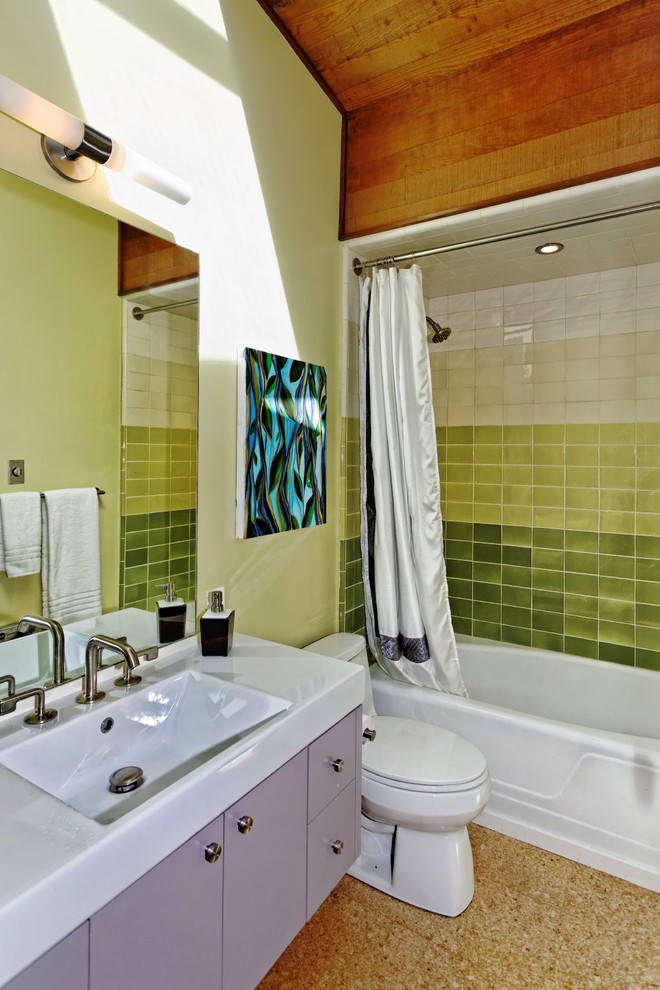 Modelo de cuarto de baño vintage con lavabo integrado, armarios con paneles lisos, puertas de armario grises, bañera empotrada, combinación de ducha y bañera, baldosas y/o azulejos verdes, paredes verdes y ducha con cortina