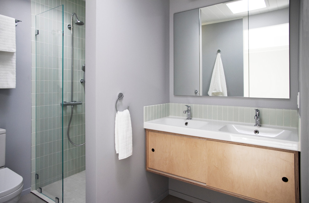 Idee per una stanza da bagno moderna con lavabo sospeso, ante lisce, ante in legno chiaro, doccia alcova, piastrelle grigie e piastrelle diamantate