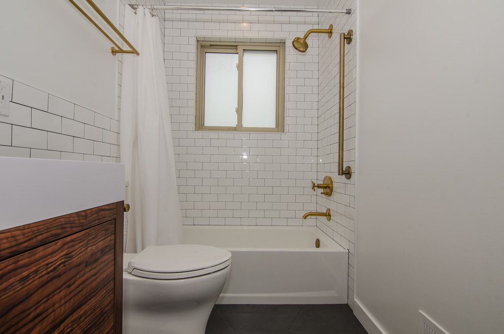Inspiration for a mid-sized 1960s kids' white tile and ceramic tile porcelain tile and gray floor alcove bathtub remodel in DC Metro with flat-panel cabinets, medium tone wood cabinets, a two-piece toilet, solid surface countertops and white countertops