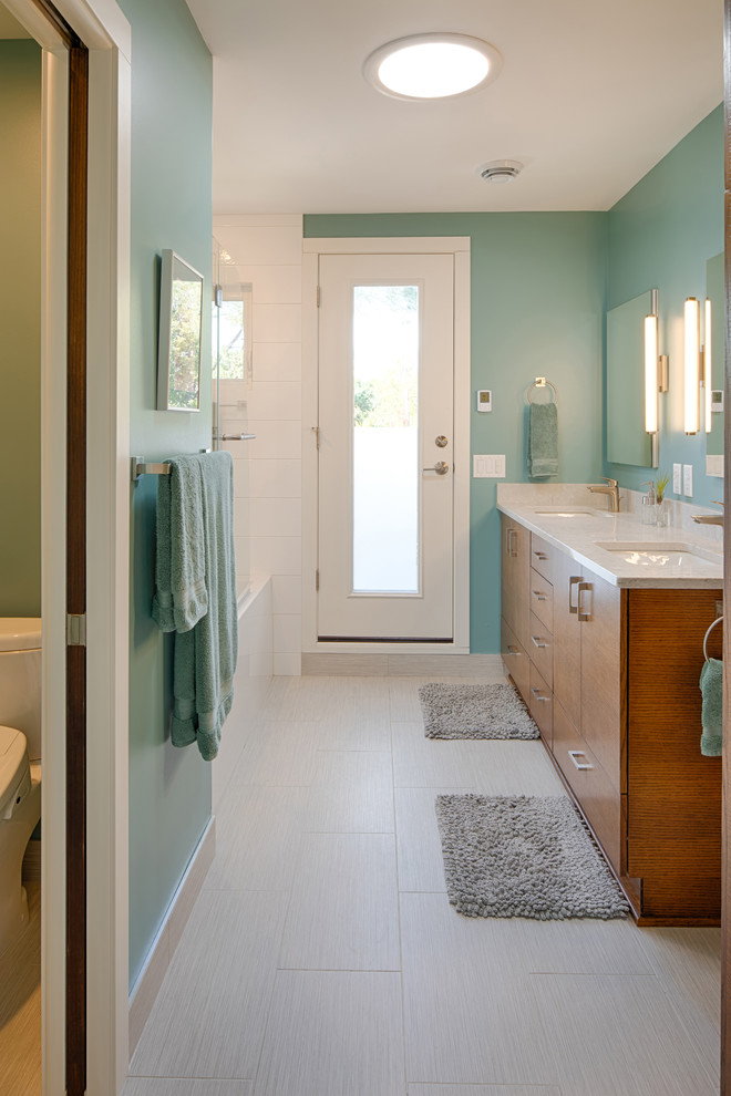 Idées déco pour une grande salle de bain principale rétro en bois brun avec un placard à porte plane, un combiné douche/baignoire, un mur bleu, un sol en carrelage de céramique, un lavabo encastré, un plan de toilette en granite, un sol beige, une cabine de douche à porte battante et un plan de toilette blanc.
