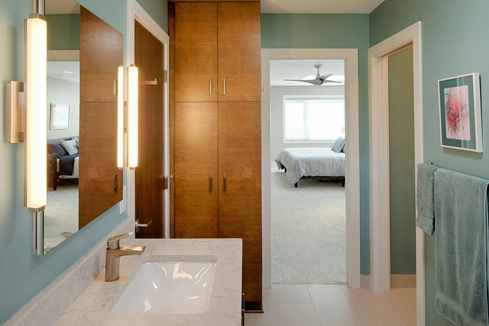 Idée de décoration pour une grande salle de bain principale vintage en bois brun avec un placard à porte plane, un combiné douche/baignoire, un mur bleu, un sol en carrelage de céramique, un lavabo encastré, un plan de toilette en granite, un sol beige, une cabine de douche à porte battante et un plan de toilette blanc.
