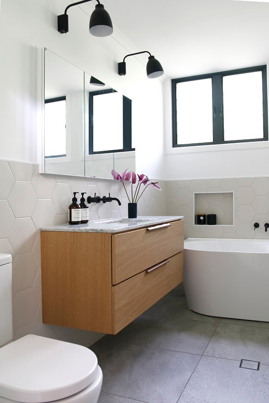 На фото: ванная комната среднего размера в стиле ретро с плоскими фасадами, фасадами цвета дерева среднего тона, белой плиткой, керамической плиткой, врезной раковиной, мраморной столешницей и белой столешницей